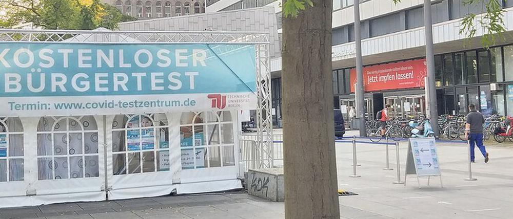 Vor dem Hauptgebäude der TU Berlin steht ein Testzelt, über der Eingangstür hängt ein Banner mit der Aufforderung "Jetzt impfen lassen!".