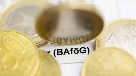 Auf einem Bafög-Antrag liegen Ein-Euro und 50-Cent-Münzen. Zu lesen ist der Schriftzug Bafög.