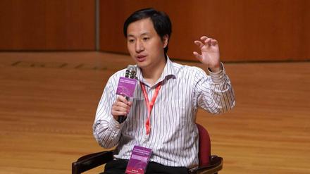 Bei einer Konferenz spricht He Jiankui in ein Mikrofon und gestikuliert.