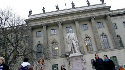 Studierende stehen vor dem Hauptgebäude der Humboldt-Universität zu Berlin.