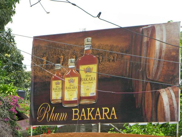 Rum wird auch in Haiti gern getrunken. Und es gibt guten einheimischen, der auch im Ausland einen guten Namen hat. Und längst gehören riesige Werbetafeln zum Straßenbild in der Hauptstadt. Auch der Rum Barbancourt wird kräftig beworben. 