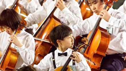  Immer mehr musikalische Könner kommen aus Fernost. Der Grund ist wahrscheinlich die frühe und vergleichsweise strikte Ausbildung vieler Talente. Alljährliches "Suzuki Method Grand Concert" in Japan 2001 (Arichivbild).
