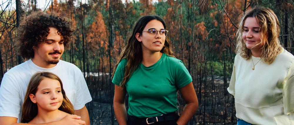 Die Geschwister Martim (l.) und Claudia Agostinho sowie die kleine Mariana Agostinho stehen mit Catarina Mota (2.v.r) im verbrannten Waldgebiet in Leiria (Archivbild).