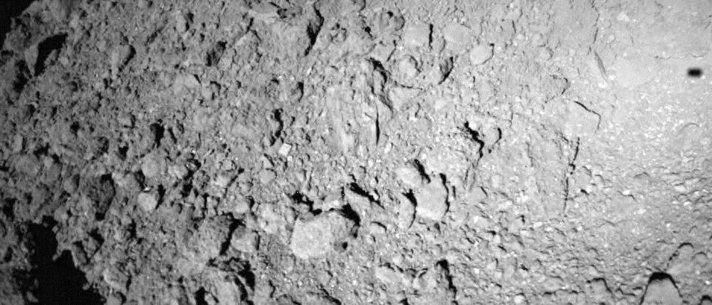 Auf dem Weg herab zum Asteroiden Ryugu schoss der Landeroboter "Mascot" ein Bild seines Schattens (oben rechts) auf dem nur 900 Meter großen Gesteinsbrocken.