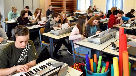 An der Oberschule in Pegau (Sachsen) üben Schülerinnen und Schüler der 7. Klasse im Musikunterricht eine Melodie am Keyboard.