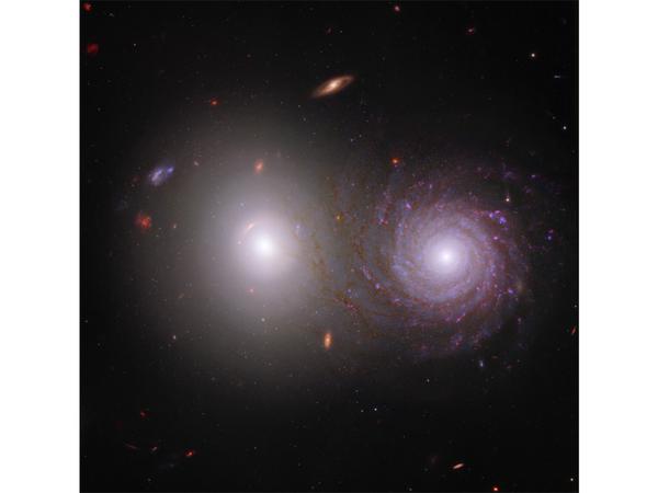 Combining images from Webb and Hubble, this image shows two galaxies, dubbed VV 191 by experts.  Thanks to Webb's near-infrared measurements, the long and delicate arms of the spiral galaxy on the right can be shown in particularly great detail.  Although both objects appear very close together from this perspective, in reality they are far apart and do not interact with each other. 