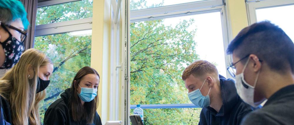 Schülerinnen und Schüler einer 13. Klasse in Hamburg arbeiten mit Mund-Nasenschutz an Laptops in ihrem Klassenraum.