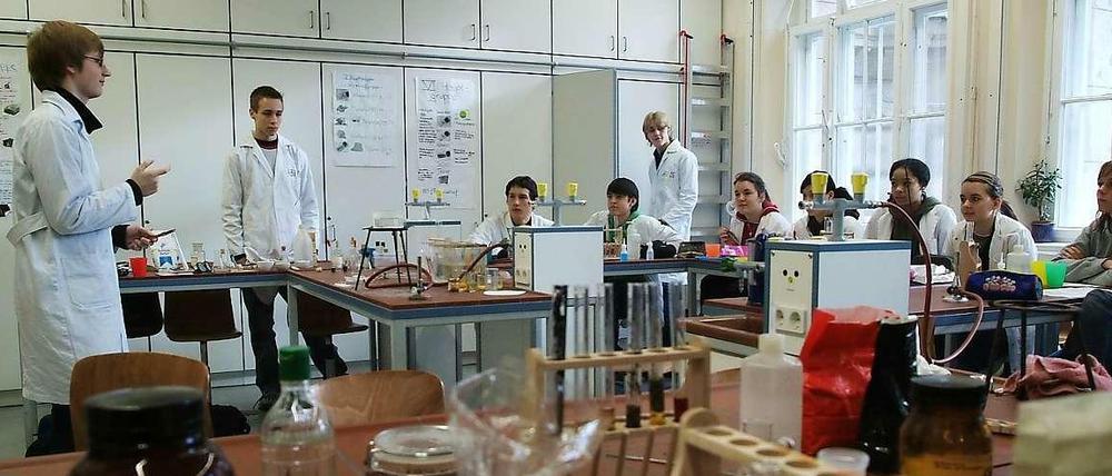 Schüler unterrichten Schüler in einem Chemie-Labor.