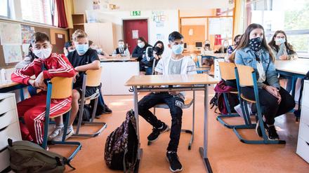 Schüler einer 7. Klasse einer Hamburger Stadtteilschule sitzen zu Beginn des Unterrichts mit Mund-Nasen-Bedeckungen im Klassenraum