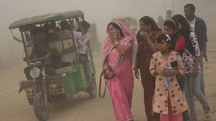 Smog in Neu Delhi, Indien: Frauen halten sich Tücher vor den Mund. 