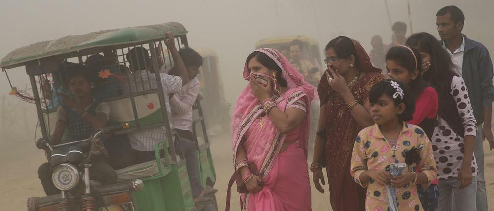 Smog in Neu Delhi, Indien: Frauen halten sich Tücher vor den Mund. 