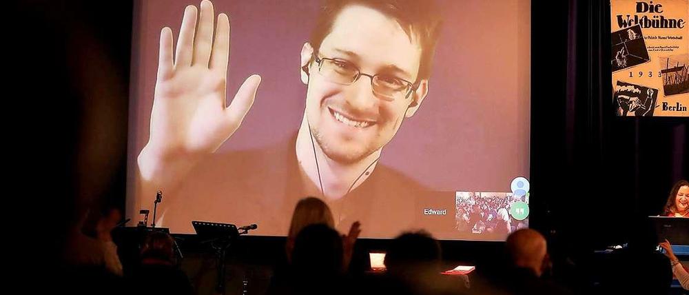 Edward Snowden ist auf einer Videoleinwand zu sehen, er wirkt dem Publikum im Saal zurück.