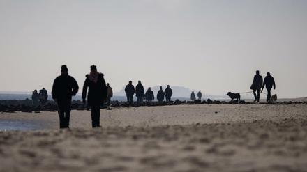 Spaziergänger am Strand bei Wyk auf der Nordseeinsel Föhr.