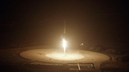Landeanflug. Das Foto zeigt wie die "Falcon-9" aufrecht stehend zur Erde zurückkehrt und landet. 