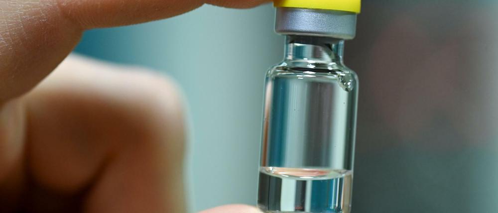 Ein Mitarbeiter hält im Werk eines deutschen Impfstoffherstellers eine Ampulle, in die später ein Impfstoff abgefüllt wird.