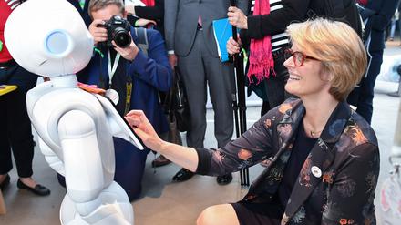 Forschungsministerin Anja Karliczek (CDU) kommuniziert mit einem humanoiden Roboter.