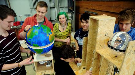 Studenten im MINT grün Programm basteln an einer Apparatur, in der ein Globus eingebaut ist.