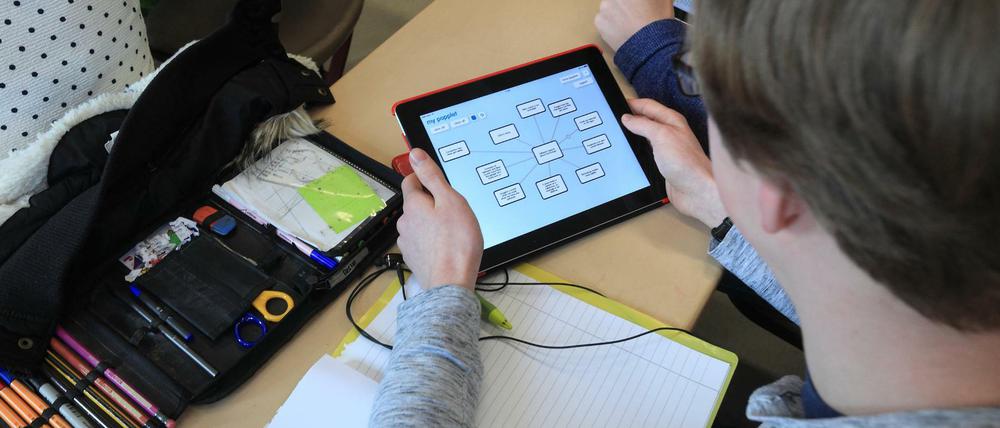 Ein Schüler arbeitet im Klassenraum mit einem Tablet-Computer.