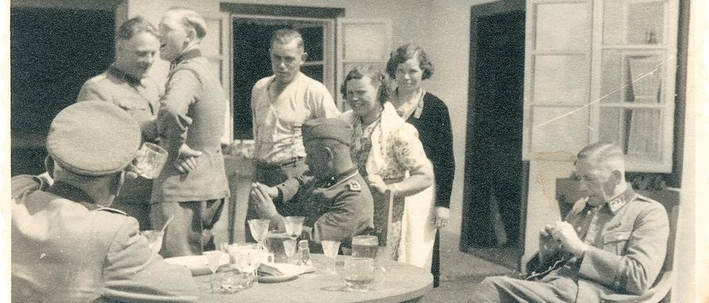Johann Niemann (3. v.l.) und Kollegen sitzen im Vernichtungslager Sobibor um einen Tisch und trinken Alkohol.