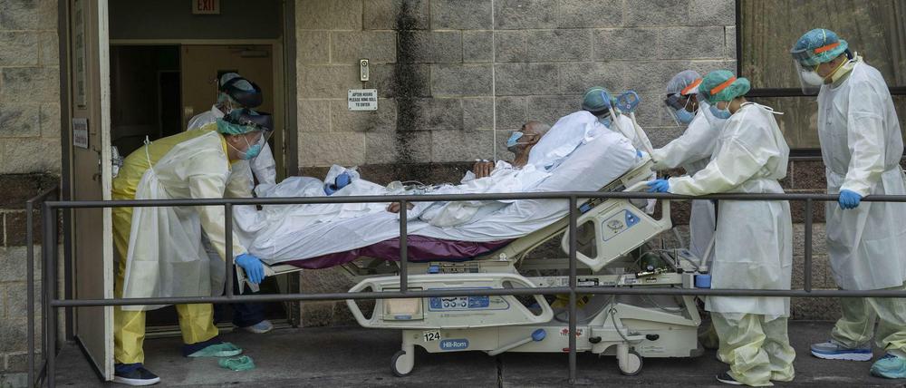 Medizinische Mitarbeiter in Texas transportieren einen Patienten außerhalb der Intensivstation.