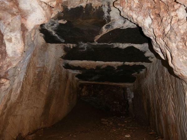 Ein in den Fels gehauener Graben, der an der Oberseite mit Steinplatten abgedeckt ist und so zum Tunnel wird.
