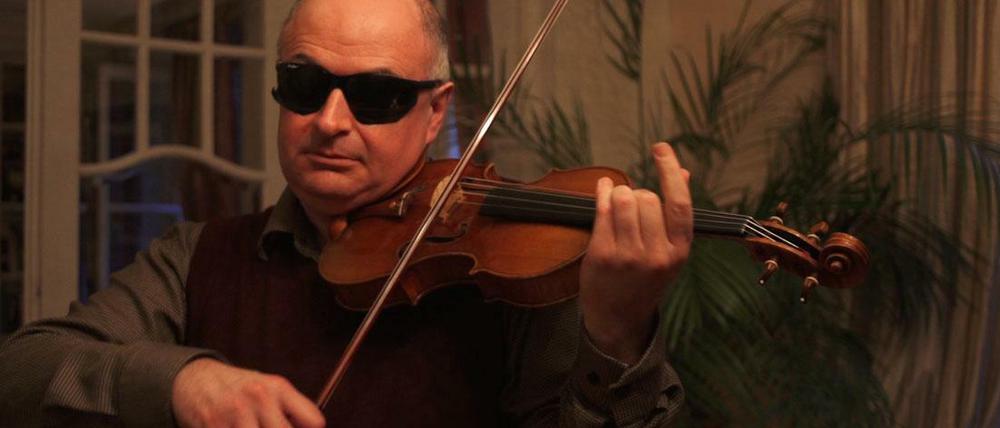 Blindtest. Der Solokünstler Ilja Kaler testet eine der zwölf Violinen. Die modifizierte Schweißerbrille und die schwache Beleuchtung sollen verhindern, dass er das Instrument erkennt. 