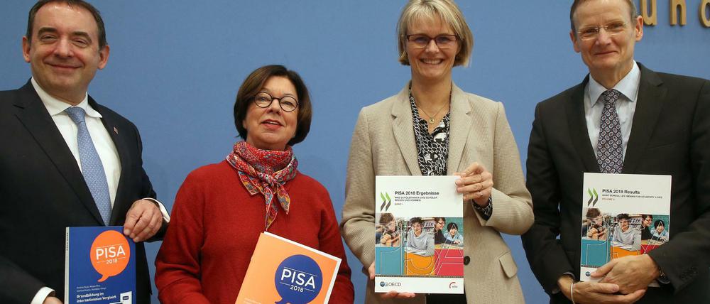 Gruppenfoto mit Minister*innen und Experten, die Berichtsbände der Pisa-Studie in den Händen halten.