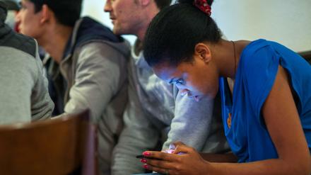 Ein Mädchen aus Eritrea liest in einem Mecklenburger Heim vergangenes Jahr eine Nachricht auf ihrem Smartphone.