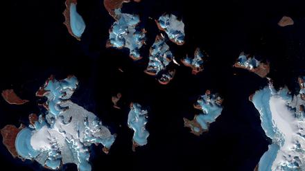 Abschmelzende Gletscher in der russischen Arktis sind auf einem undatierten Satellitenbild zu sehen. Die Gletscher im Bild sind bläulich und mit weißem Schnee bedeckt, das darunter durch das Abschmelzen sichtbar werdende Land ist braun-rötlich. Die Schneedecke auf den Gletschern ist auch ein Indikator für die schwindende Masse der Gletscher