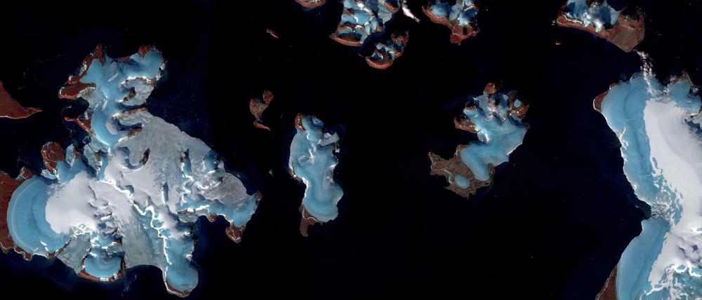 Abschmelzende Gletscher in der russischen Arktis sind auf einem undatierten Satellitenbild zu sehen. Die Gletscher im Bild sind bläulich und mit weißem Schnee bedeckt, das darunter durch das Abschmelzen sichtbar werdende Land ist braun-rötlich. Die Schneedecke auf den Gletschern ist auch ein Indikator für die schwindende Masse der Gletscher
